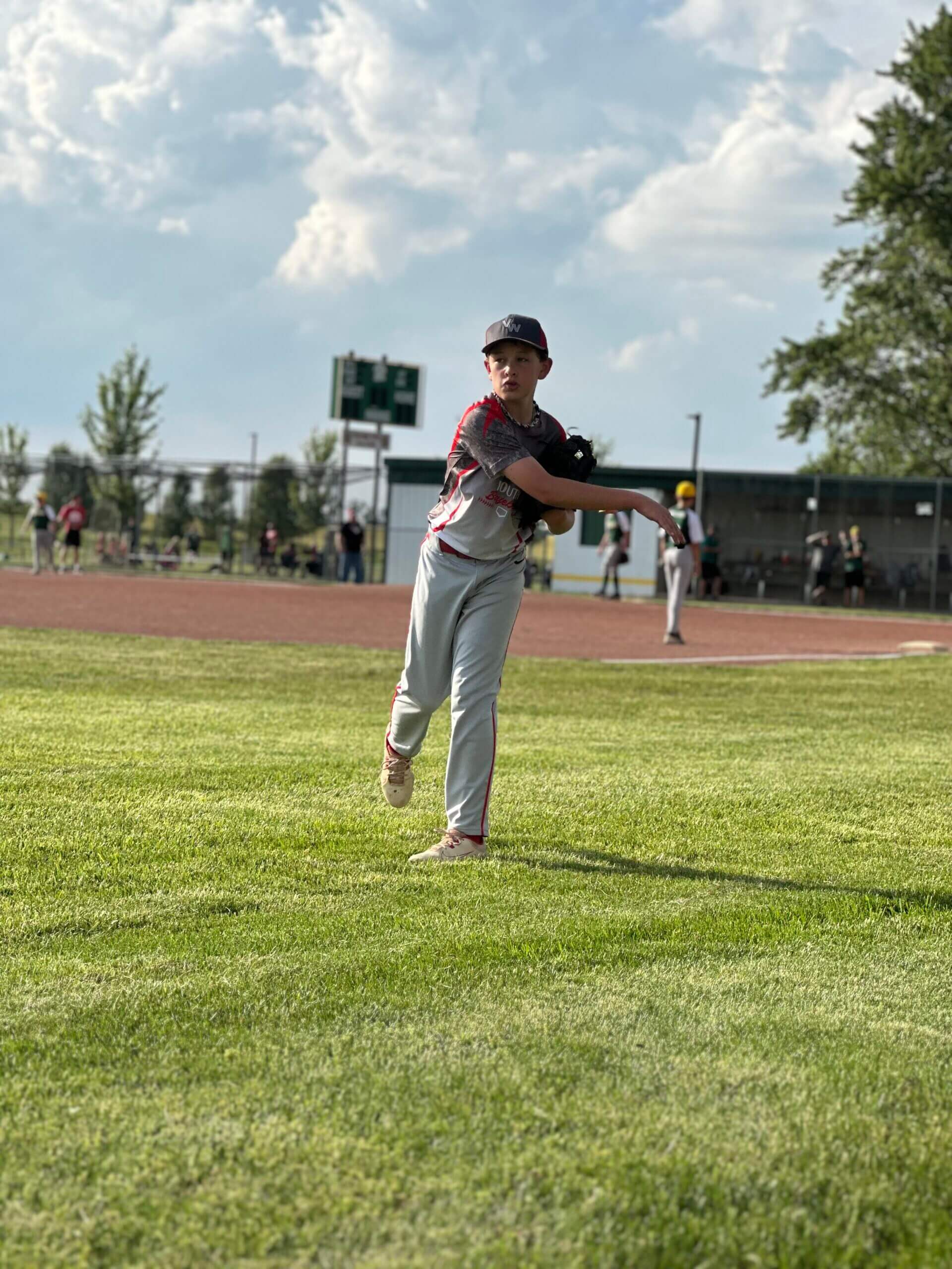 A young baseball player throwing a ball on the field.